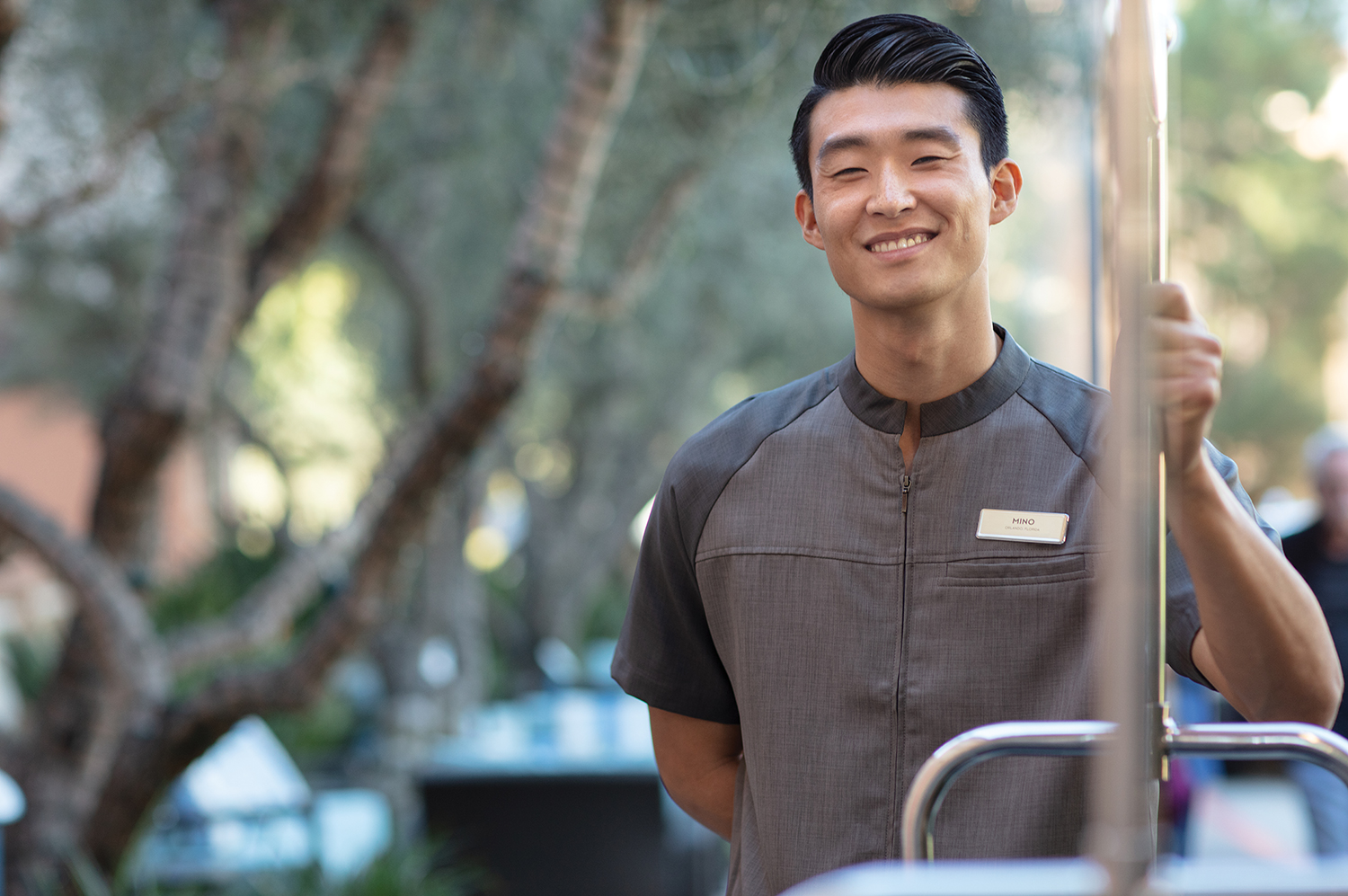 Smiling Marriott associate leaning against a pool table in a spacious, modern break room